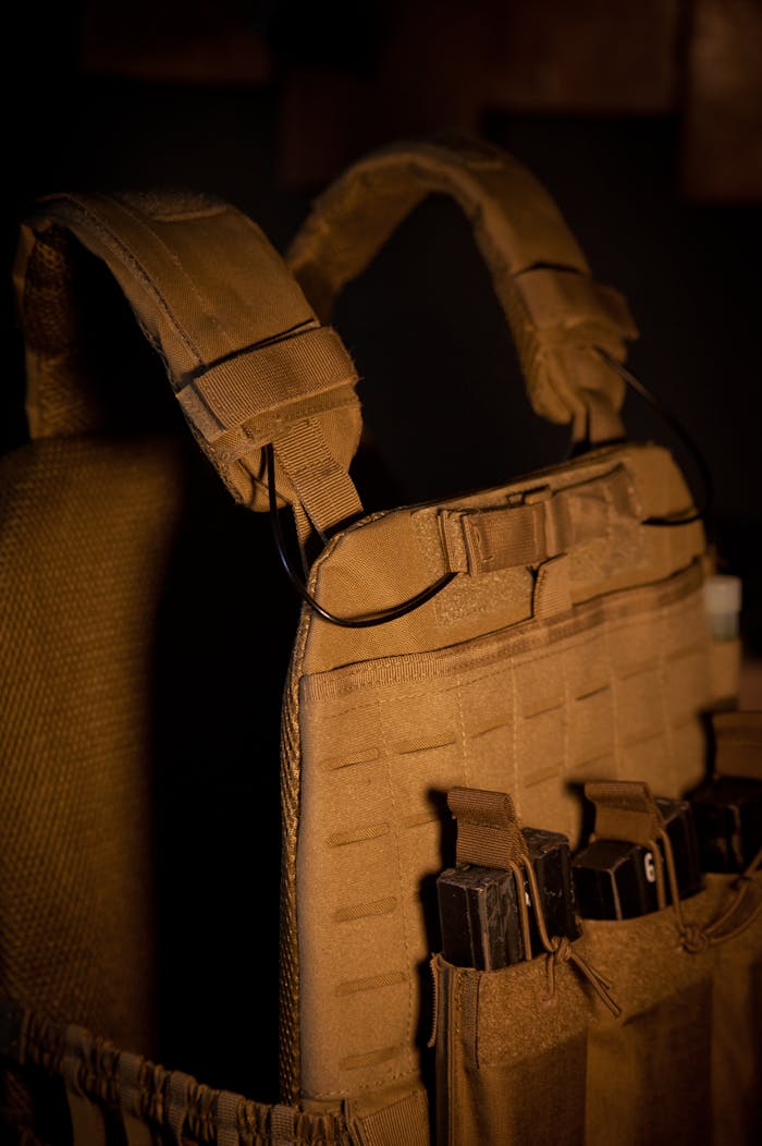 About Close-up of a tactical military vest with multiple magazine pouches in low light.